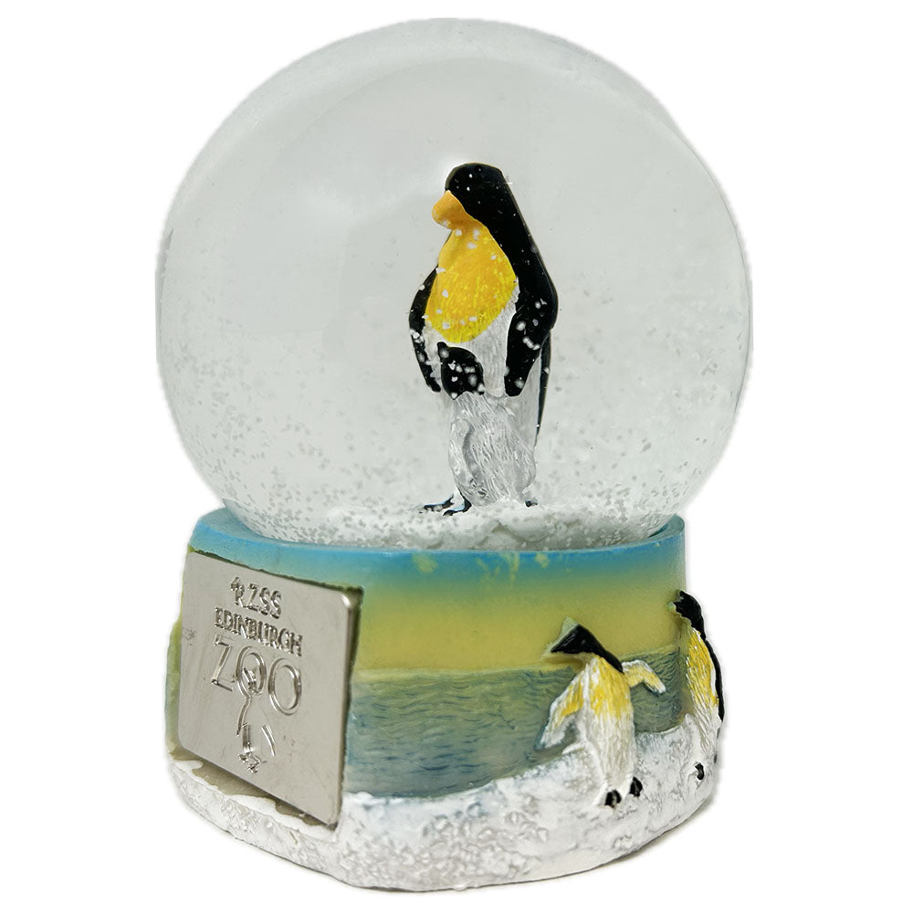 This Penguin Snow Globe with Edinburgh Zoo shield is fun and playful. Crystal clear glass filled with water and sparkly snow falling around a penguin with chick. The base is made from resin and hand painted.