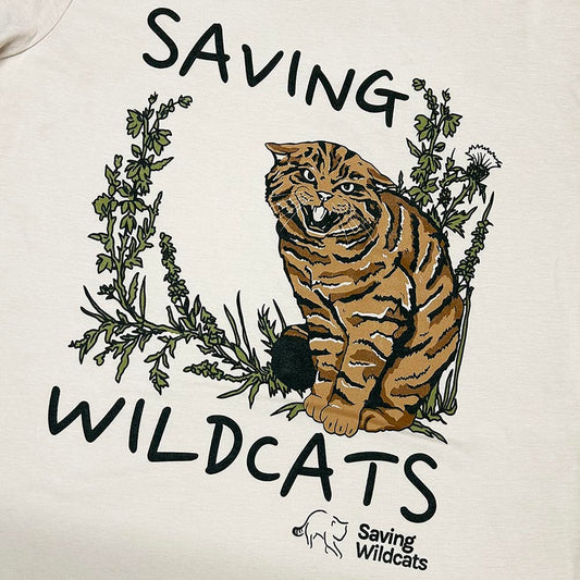 Support Saving Wildcats with this wild Saving Wildcats Men's T-shirt in Oat. The soft and sustainable organic cotton ensures you stay comfortable all day. The design features Ordie, one of the male wildcats in the Saving Wildcats conservation breeding for release centre that has fathered five wildcats that were released into the wild in 2023. His offspring include Arwen, who gave birth to two litters of wild born kittens in 2024 and Willie, a male wildcat that travelled all the way across the Cairngorms pla