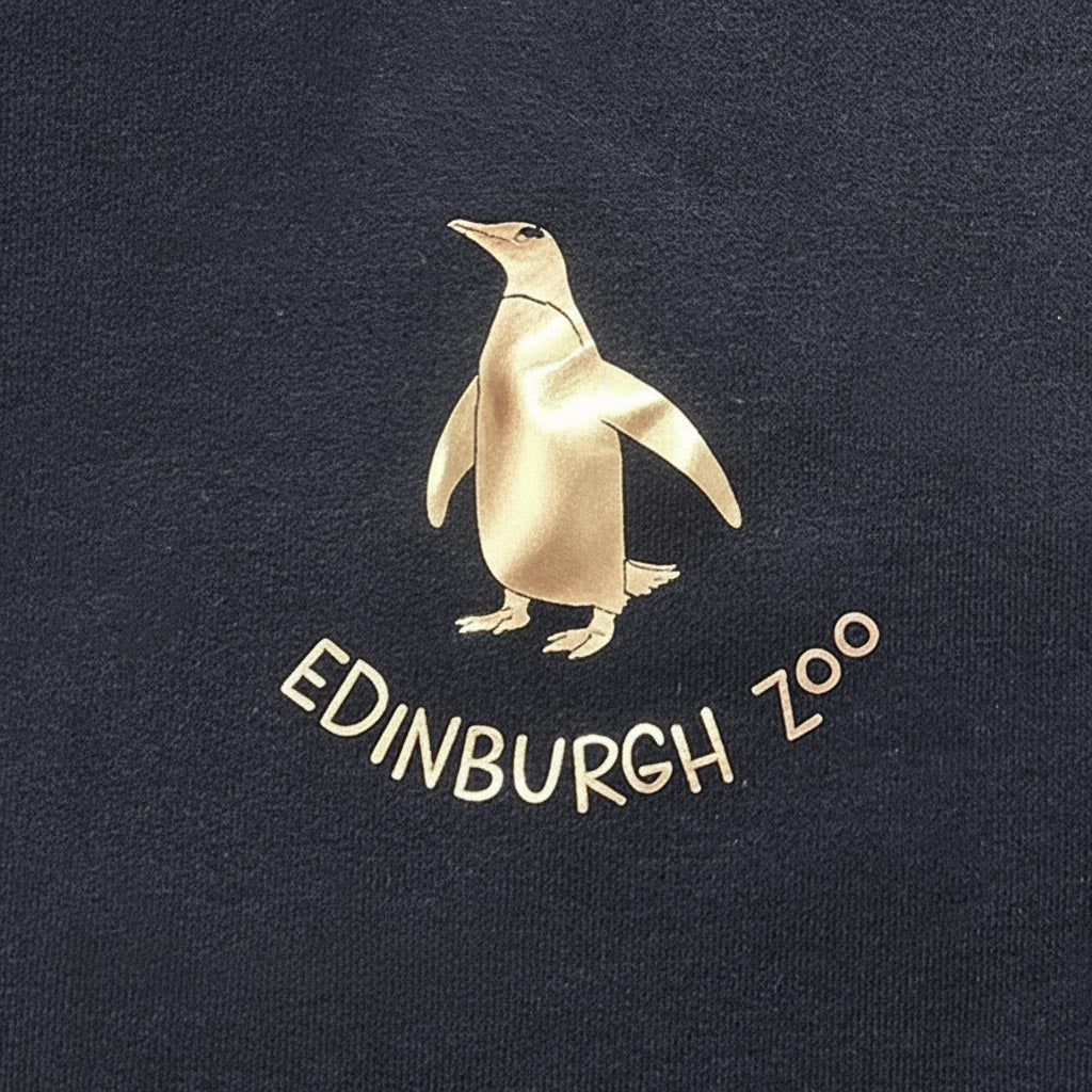 Stay warm with our Edinburgh Zoo Penguin Hooded Sweatshirt in Navy with metallic Rose Gold print. This hoody is a standard fit and is made from cotton with fleeceback inner. Sporting a kangaroo pocket at the front, metal eyelets for the thick hood strings and an adjustable hood.