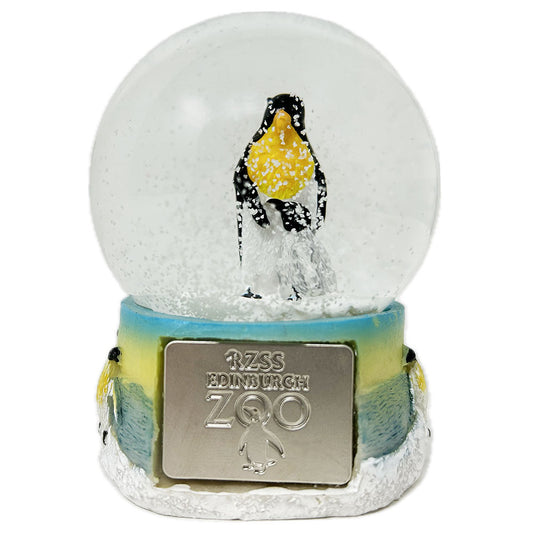 This Penguin Snow Globe with Edinburgh Zoo shield is fun and playful. Crystal clear glass filled with water and sparkly snow falling around a penguin with chick. The base is made from resin and hand painted.