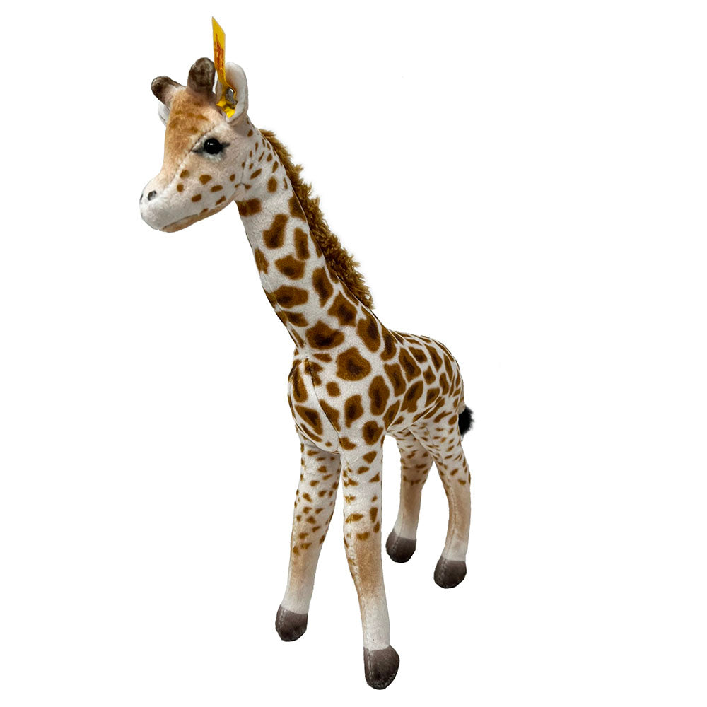 Measuring 26 cm tall, soft, Magda Masai Giraffe from Steiff is made of soft plush, and comes with contrasting hooves, main and tail.  She has cute little ears with a famous Steiff “Button in Ear”. Standing tall, this majestic African animal is supported by internal wiring to keep her steady.   26cm Tall  Hand Wash only